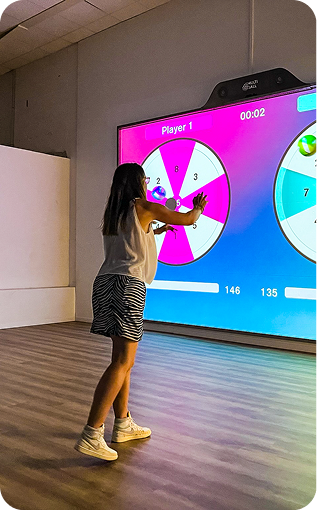 Femme qui a un balle et qui joue avec un mur interactif