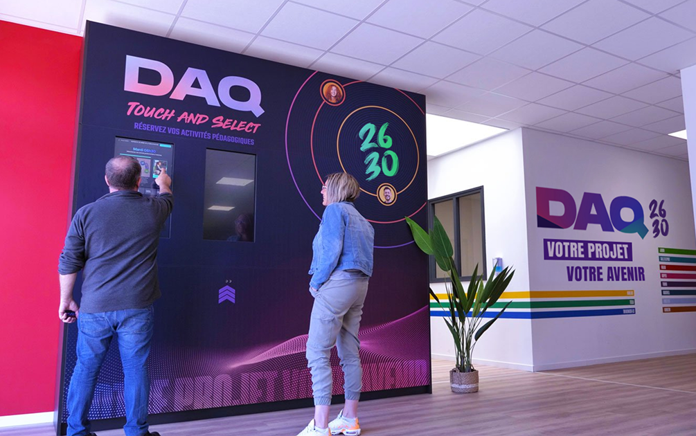 Deux stagiaire utilisant la borne interactive à l'entrée du daq